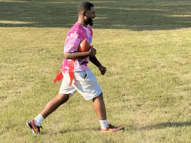 A mentor warms up before the youth flag football games